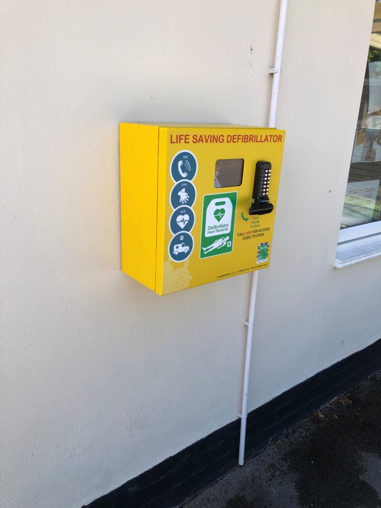 Yellow defibrillator on wall of Hollies nursery